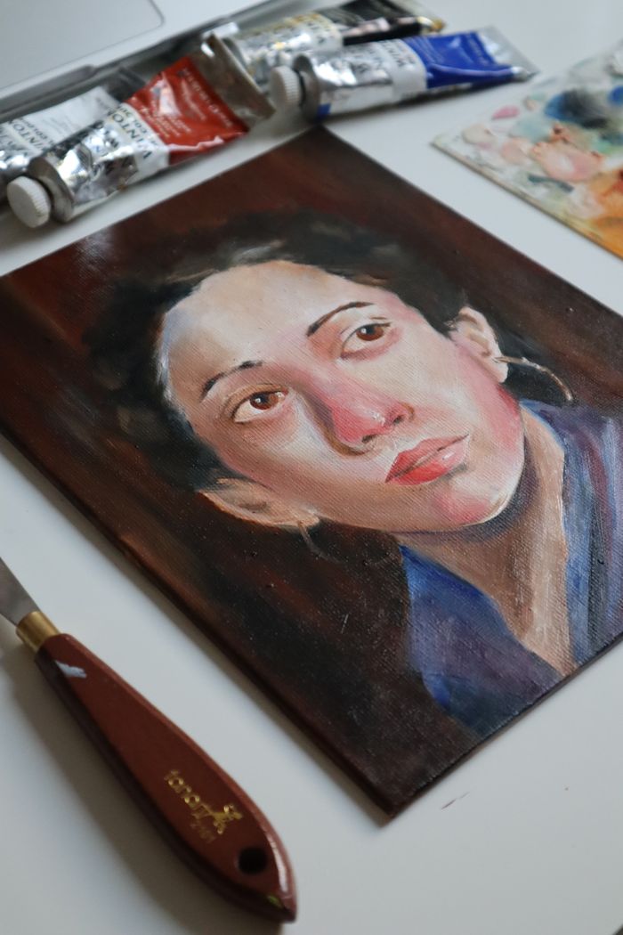 services-03 Realistic oil portrait painting with art materials on display.