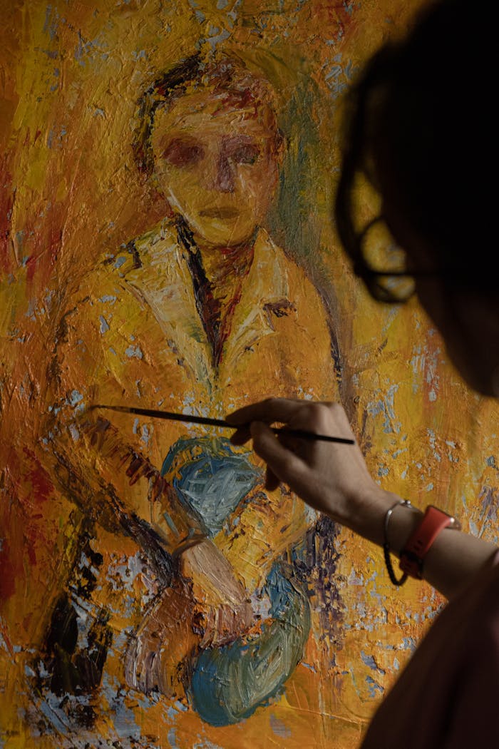 services-04 An artist's hand captures a portrait with a brush on a vibrant textured canvas.